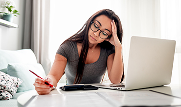 Woman looking stressed while working on taxes
