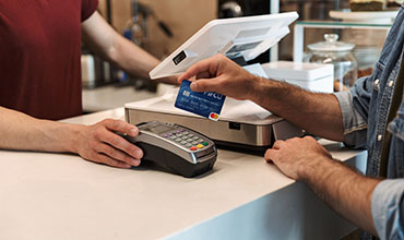 Person swiping P1FCU card at merchant machine
