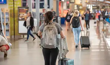 Woman with backpack walking through airport terminal