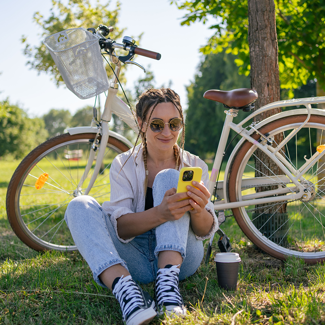 woman looking at phone in front of bike