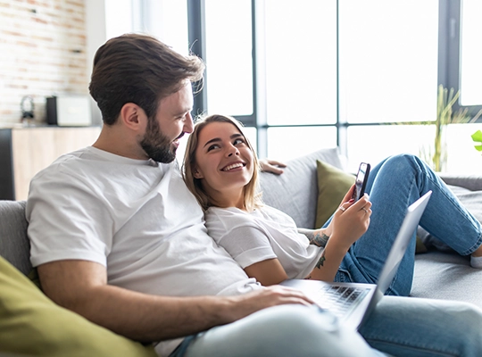 couple at home on couch with laptop