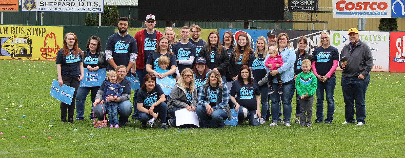 Community group photo with adults and children on sport field
