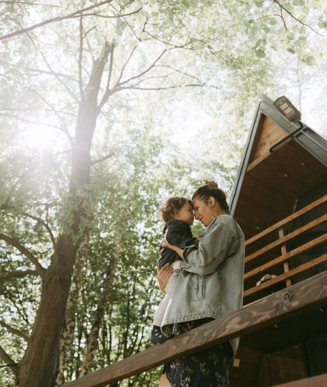 Young mother holding her child in the beautiful outdorrs.