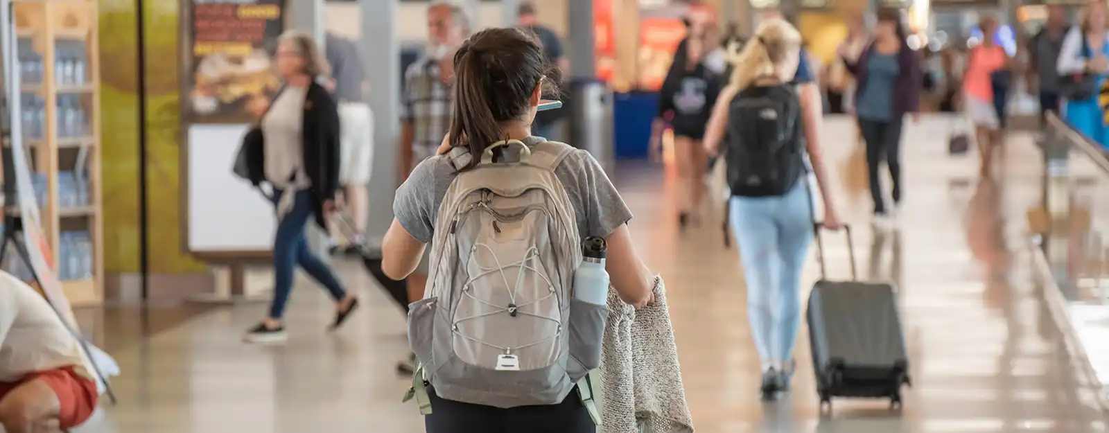 Woman with backpack walking through airport terminal