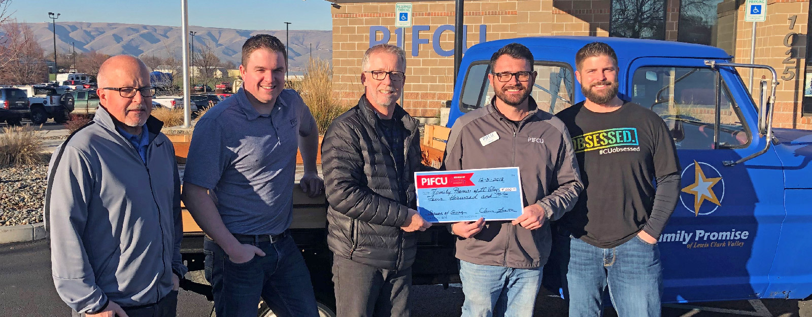 Men holding a P1FCU check and smiling