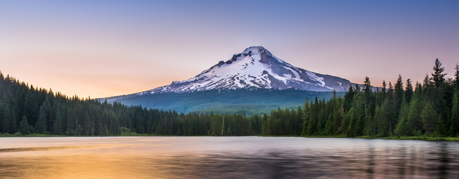 Waterfront in forrest with mountain background
