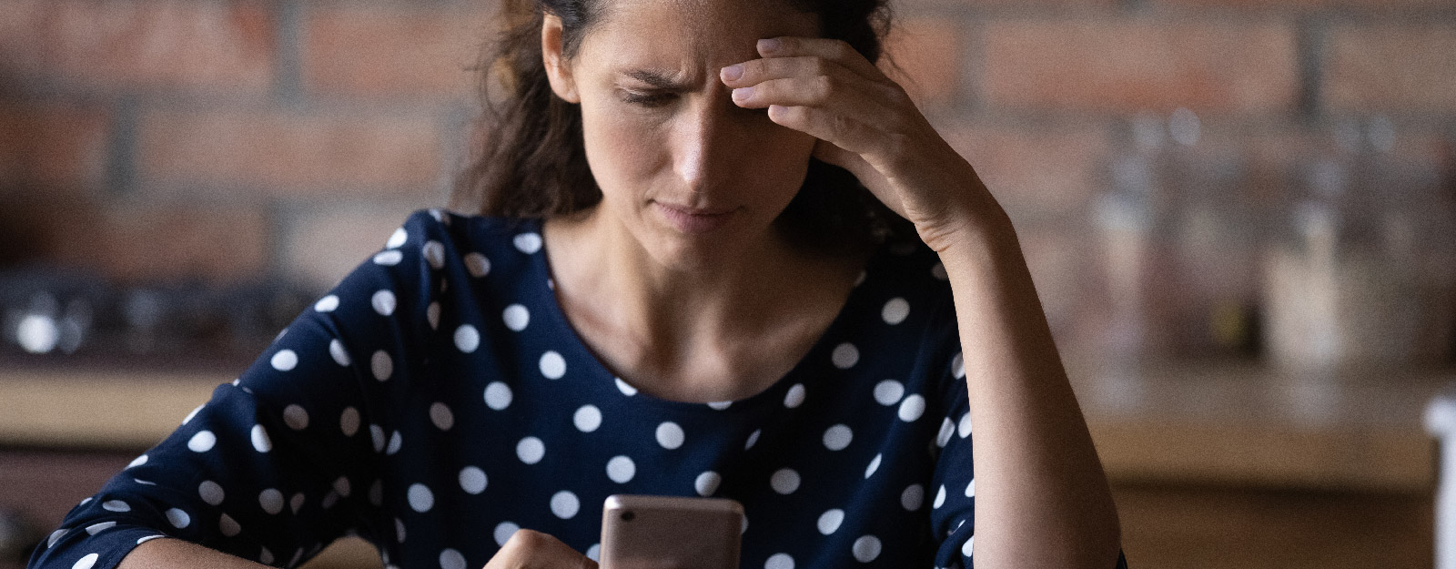 Frustrated woman looks at smartphone.