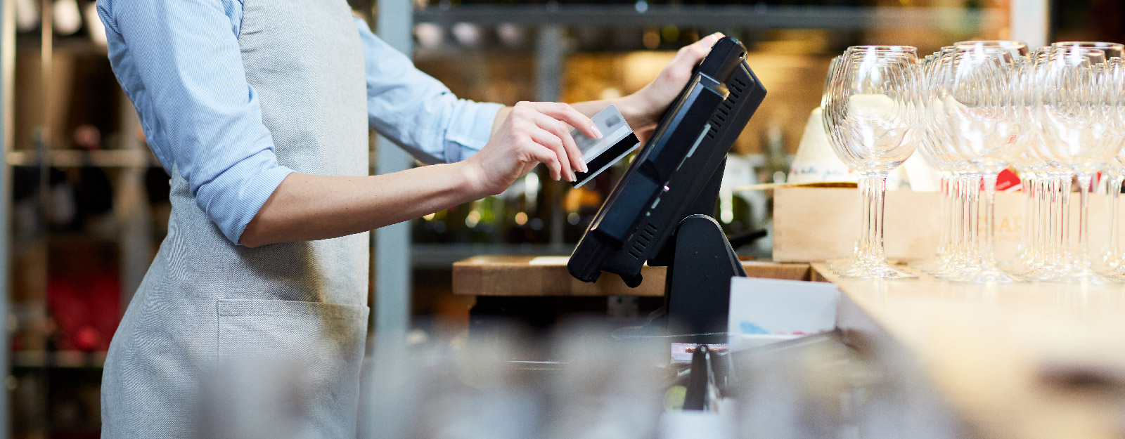 Person working at bar swiping card on merchant machine