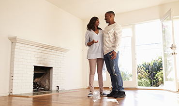 People holding each other smiling in new living room