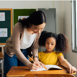 Teacher helping student at desk