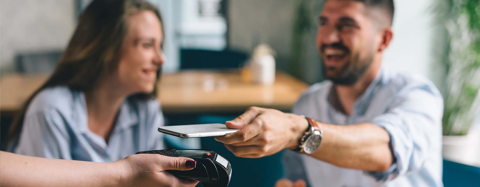 Man paying with contactless credit card on cell phone