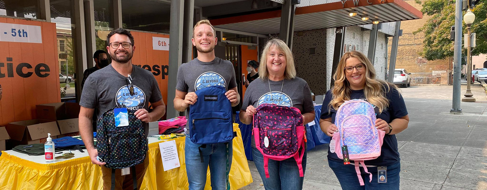 four people holding backpacks